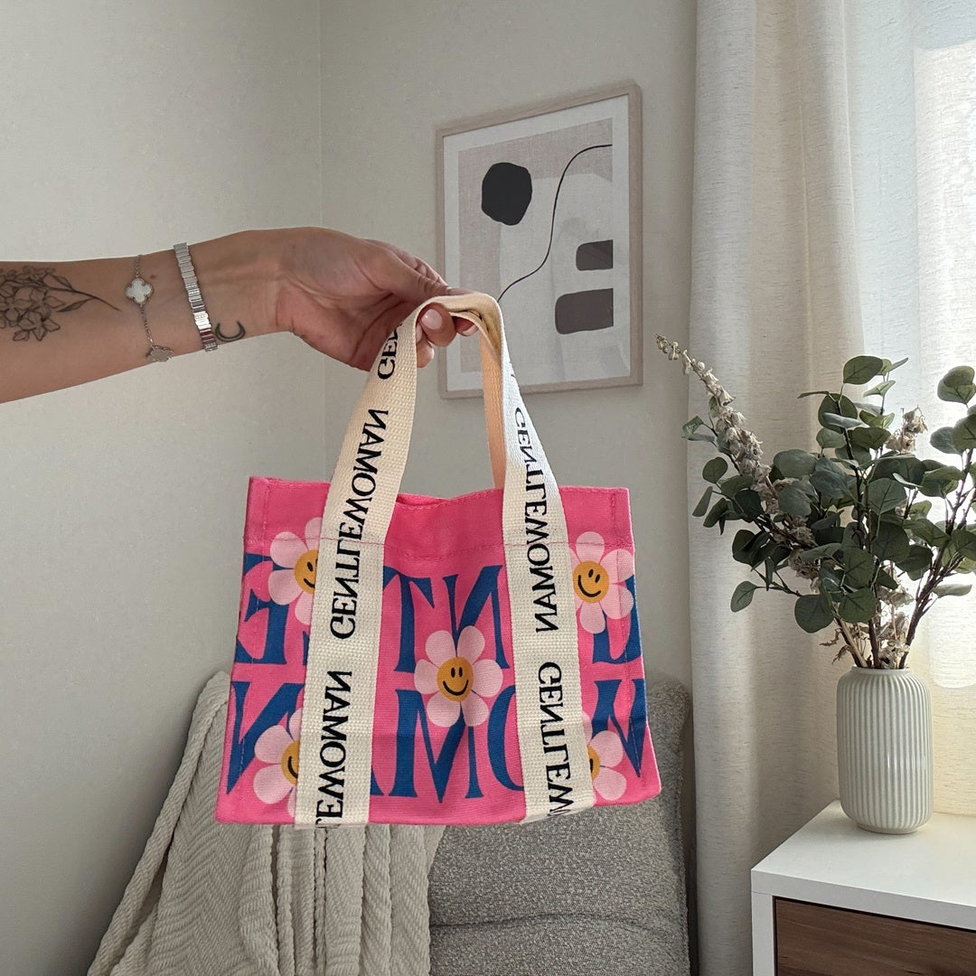 Chic pink canvas handbag with playful feminine graphics