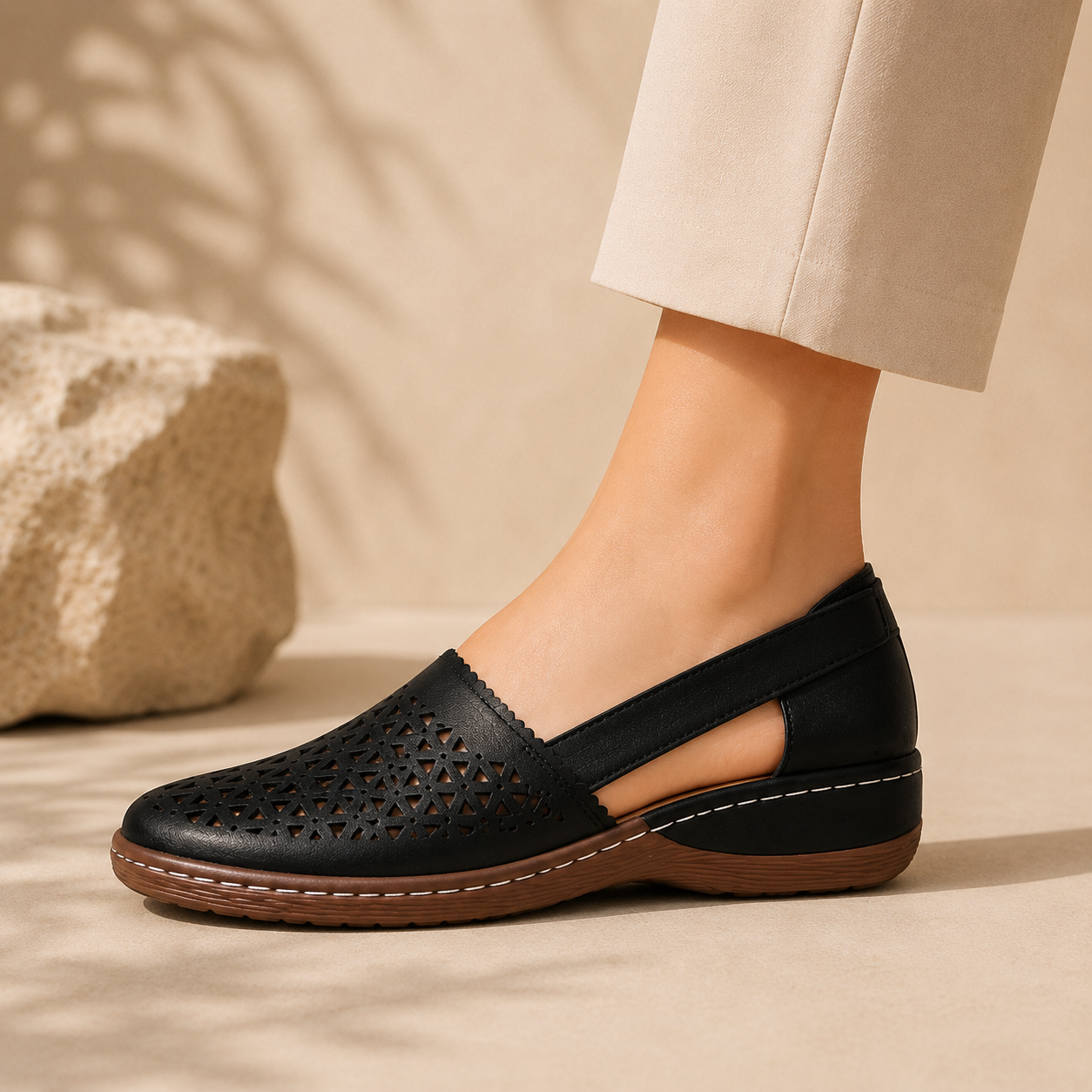 Side profile of black low wedge cutout comfort shoe