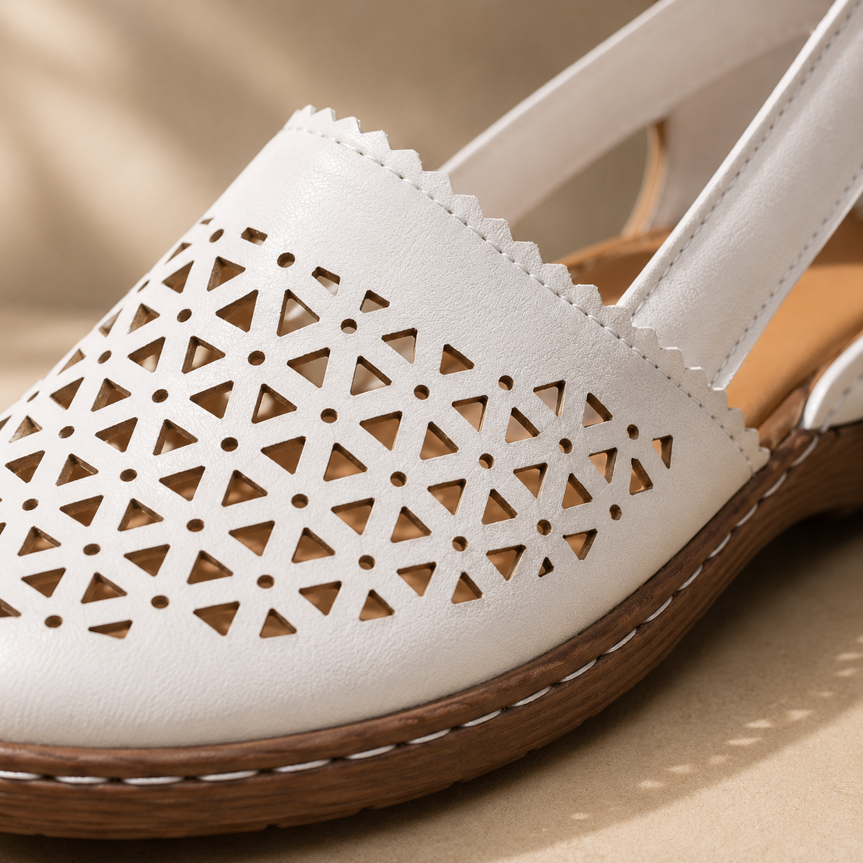Detailed close-up of white cutout shoe material and stitching