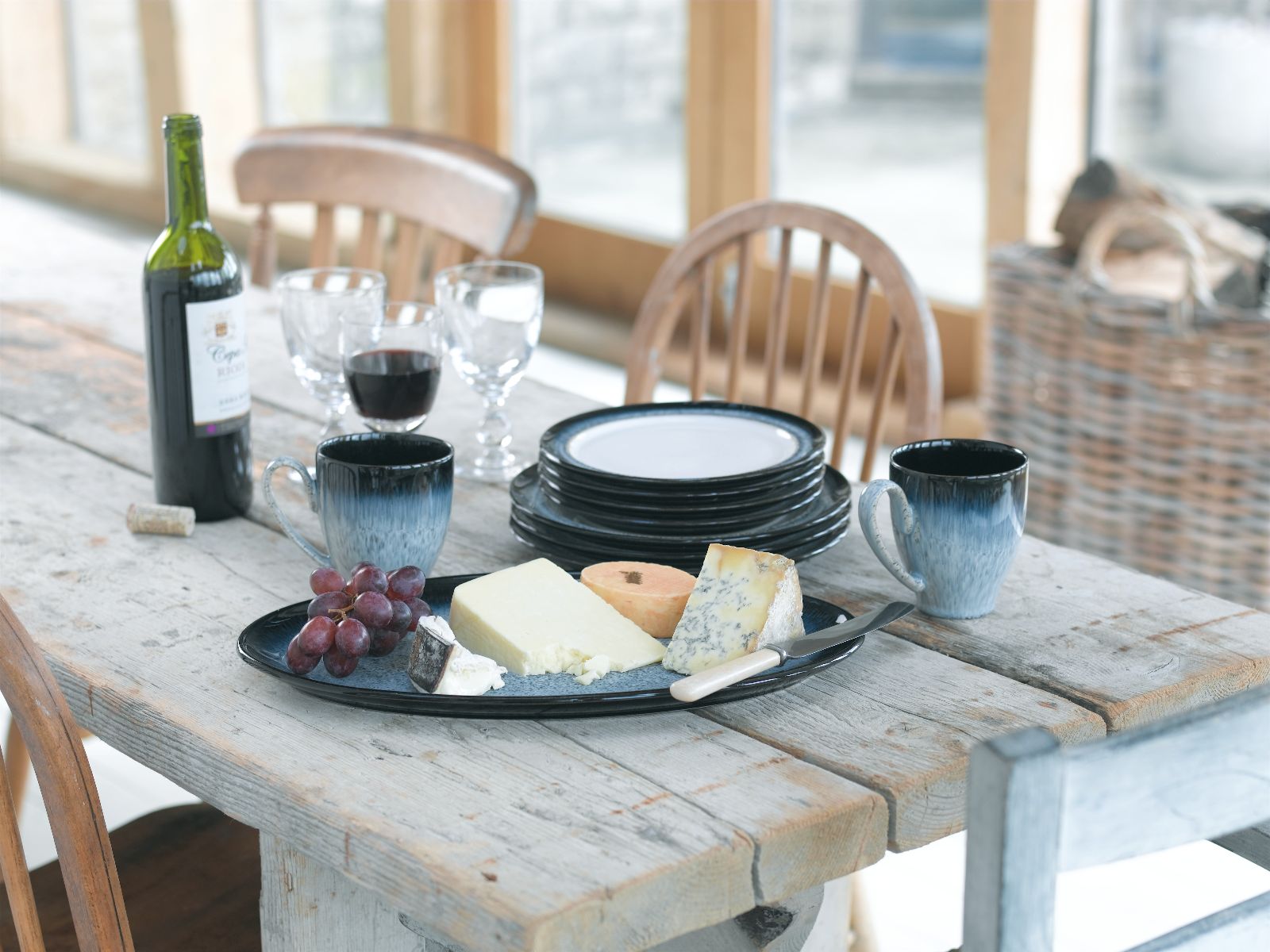 Cheese on Halo plates with red wine in the backgro