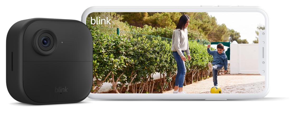 All-new Blink Outdoor 4 smart security camera is mounted to the outside of a white brick home in the natural sunlight.