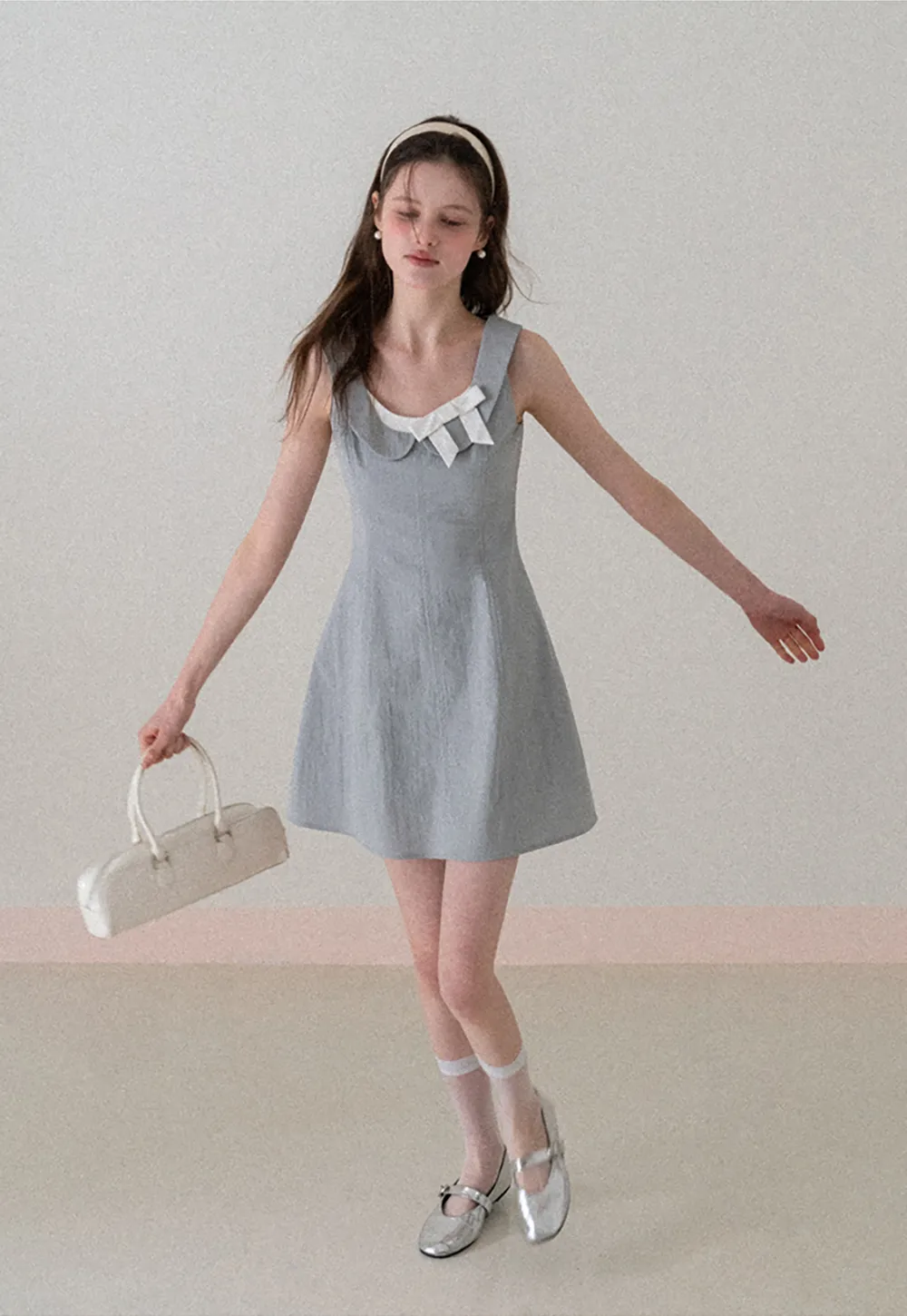 Sleeveless dress with Peter Pan collar and bow detail