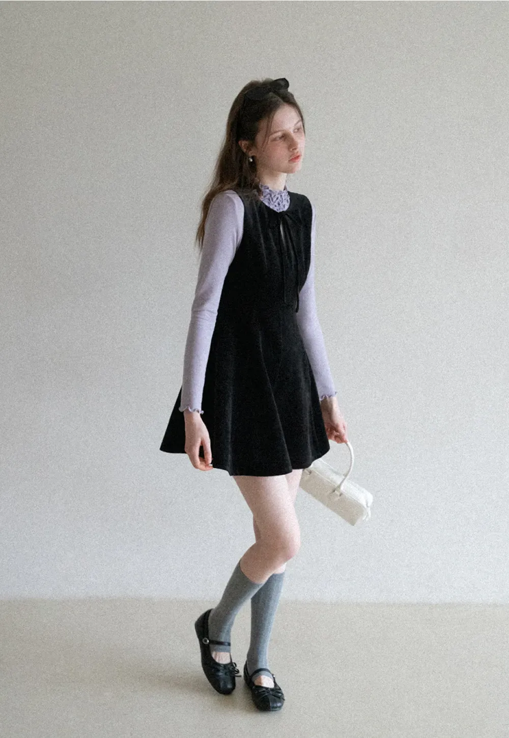 Elegant sleeveless dress with ruffled collar and bow tie design