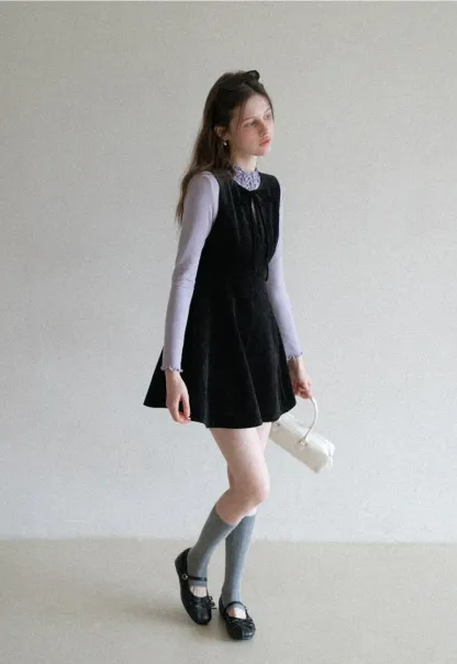 Elegant sleeveless dress with ruffled collar and bow tie design