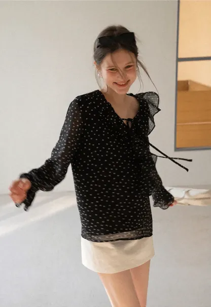 Sheer polka dot blouse with ruffled neckline and long sleeves