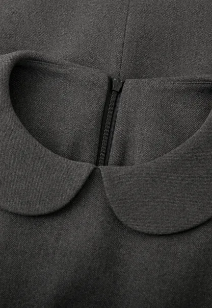 Elegant sleeveless dress with collar layered over polka dot top