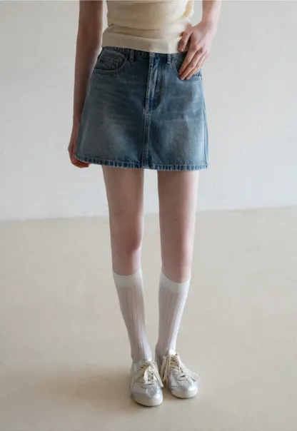 Denim mini skirt with frayed hem and front pockets