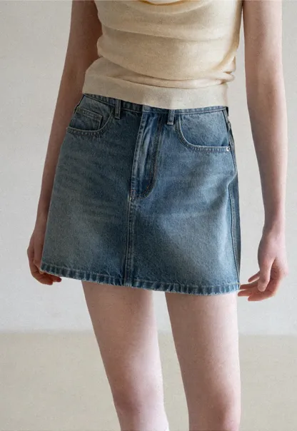 Denim mini skirt with frayed hem and front pockets
