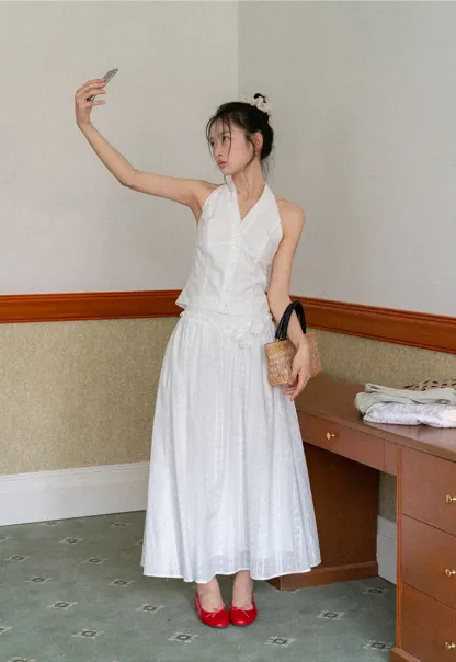 Halter neck sleeveless top with buttons and pleated skirt