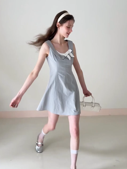 Sleeveless dress with Peter Pan collar and bow detail