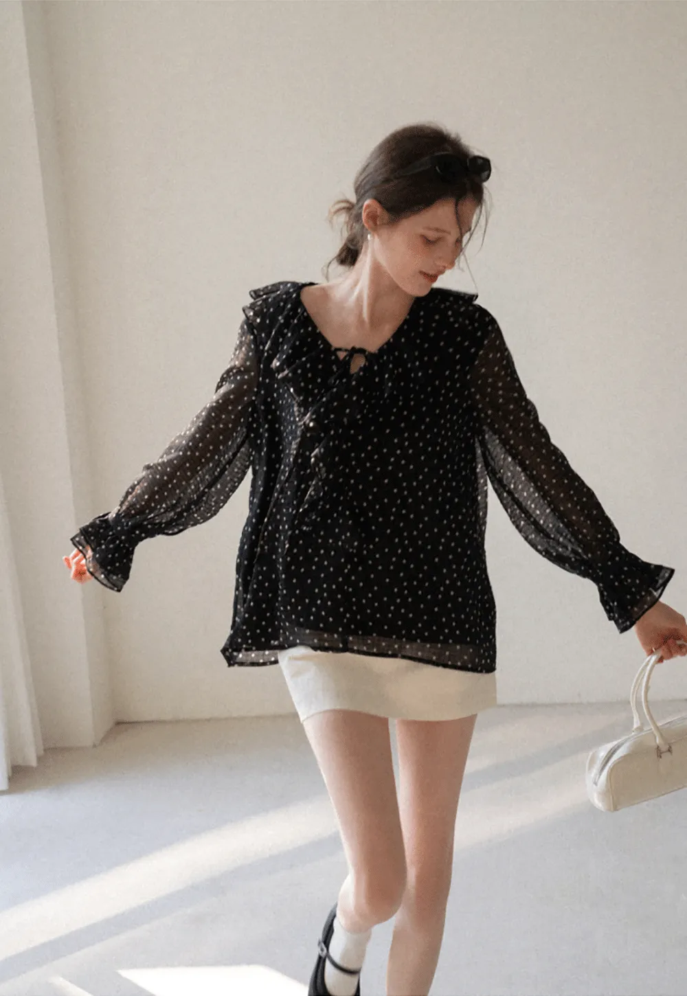 Sheer polka dot blouse with ruffled neckline and long sleeves