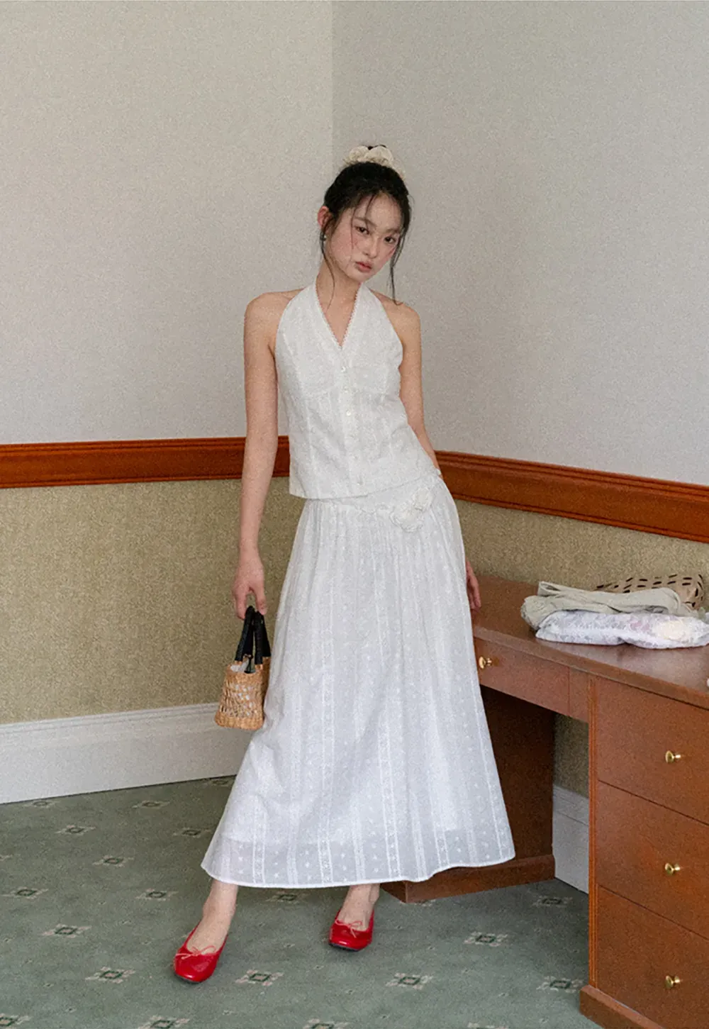 Halter neck sleeveless top with buttons and pleated skirt