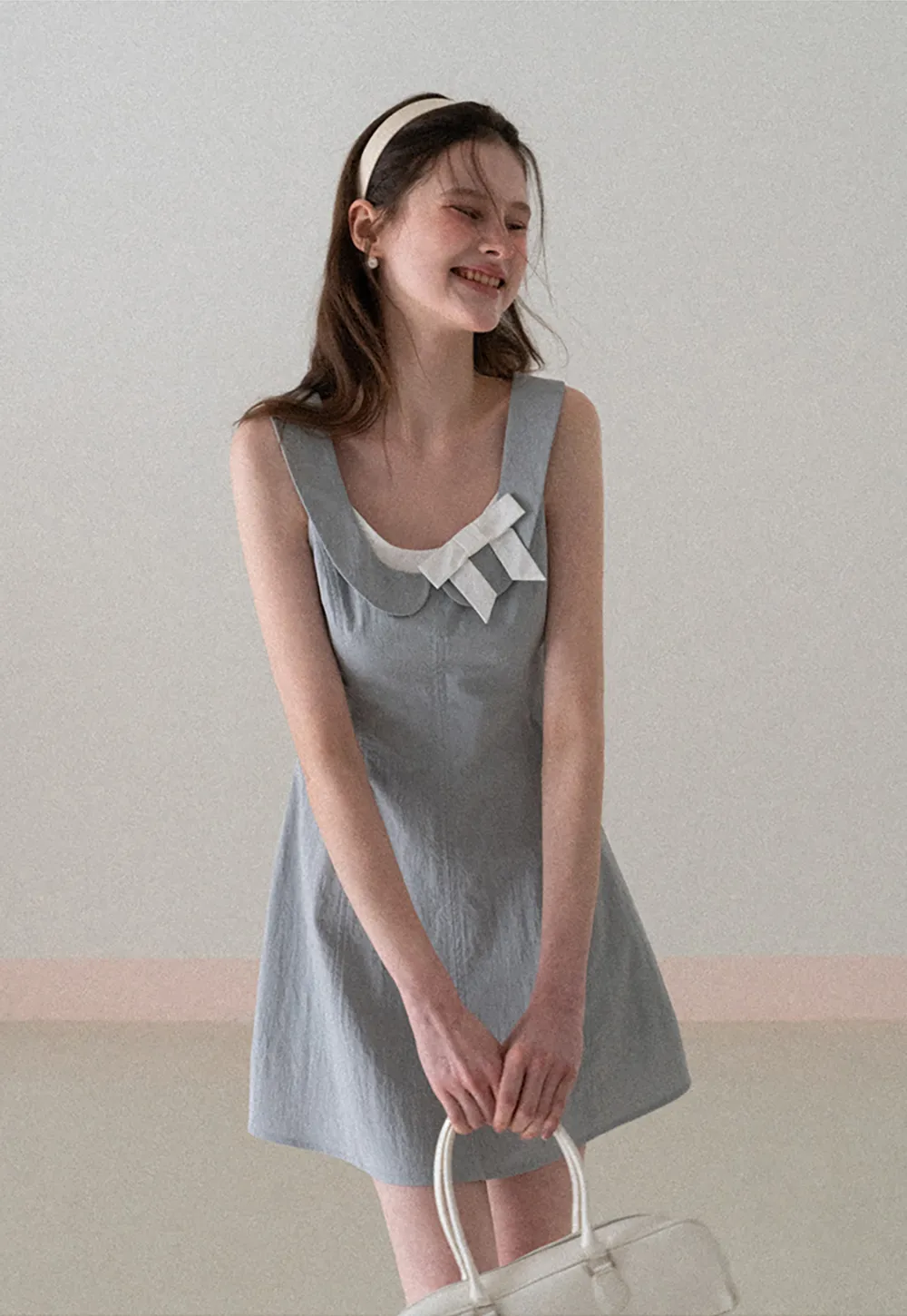 Sleeveless dress with Peter Pan collar and bow detail