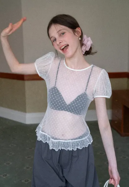 Sheer polka dot top with ruffled hem and puff sleeves