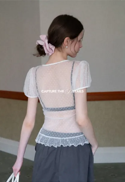 Sheer polka dot top with ruffled hem and puff sleeves