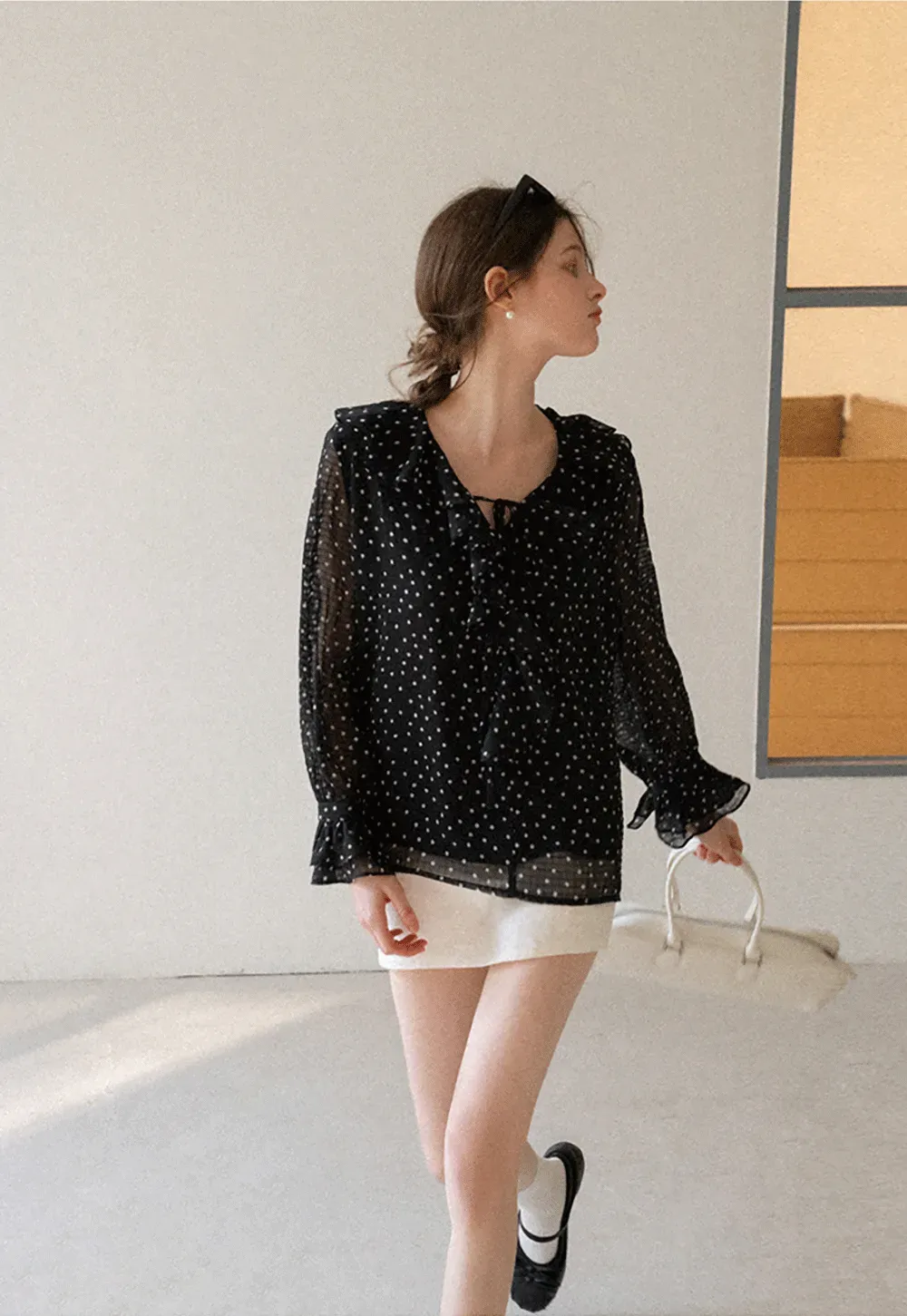 Sheer polka dot blouse with ruffled neckline and long sleeves