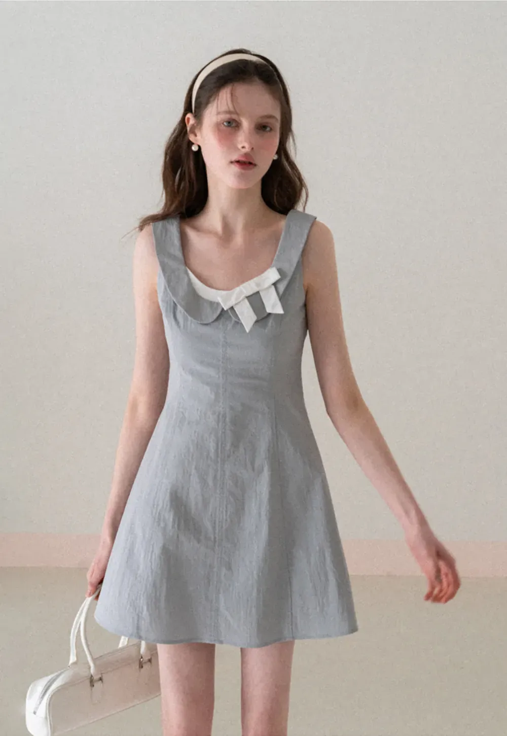 Sleeveless dress with Peter Pan collar and bow detail