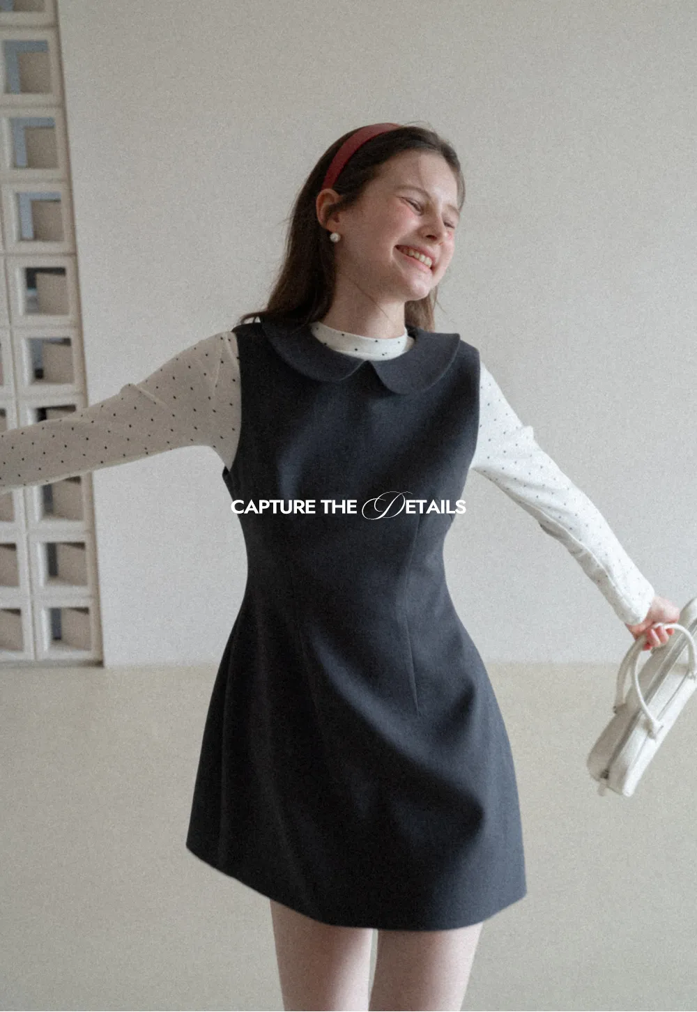 Elegant sleeveless dress with collar layered over polka dot top