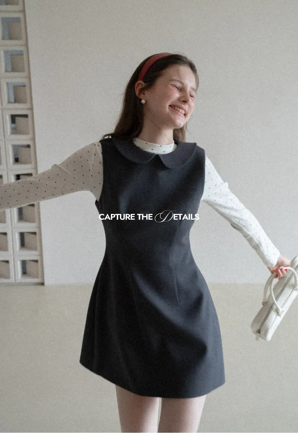 Elegant sleeveless dress with collar layered over polka dot top