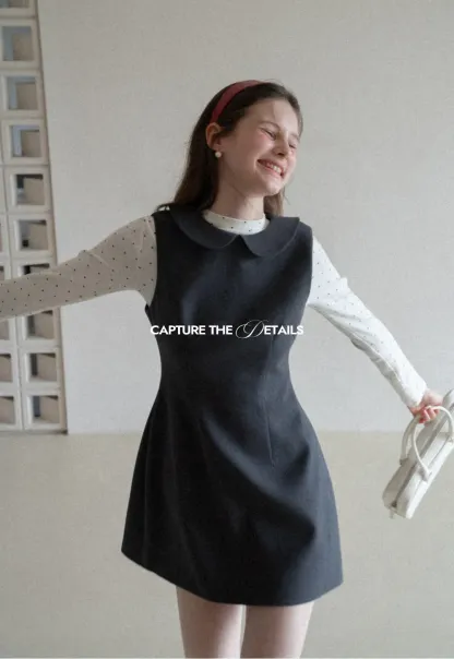 Elegant sleeveless dress with collar layered over polka dot top