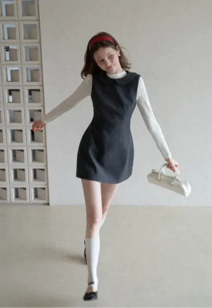 Elegant sleeveless dress with collar layered over polka dot top