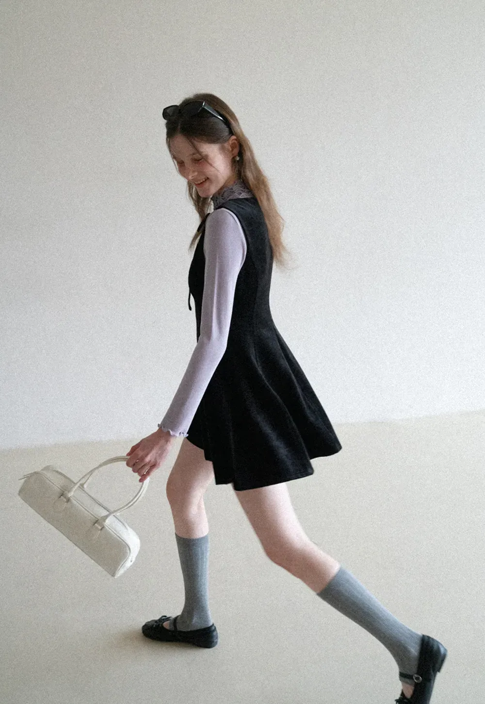 Elegant sleeveless dress with ruffled collar and bow tie design