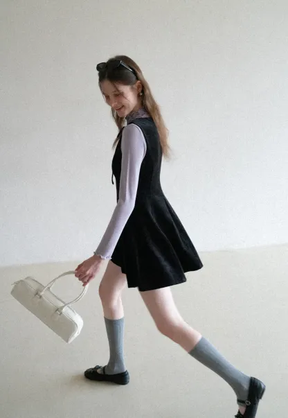 Elegant sleeveless dress with ruffled collar and bow tie design