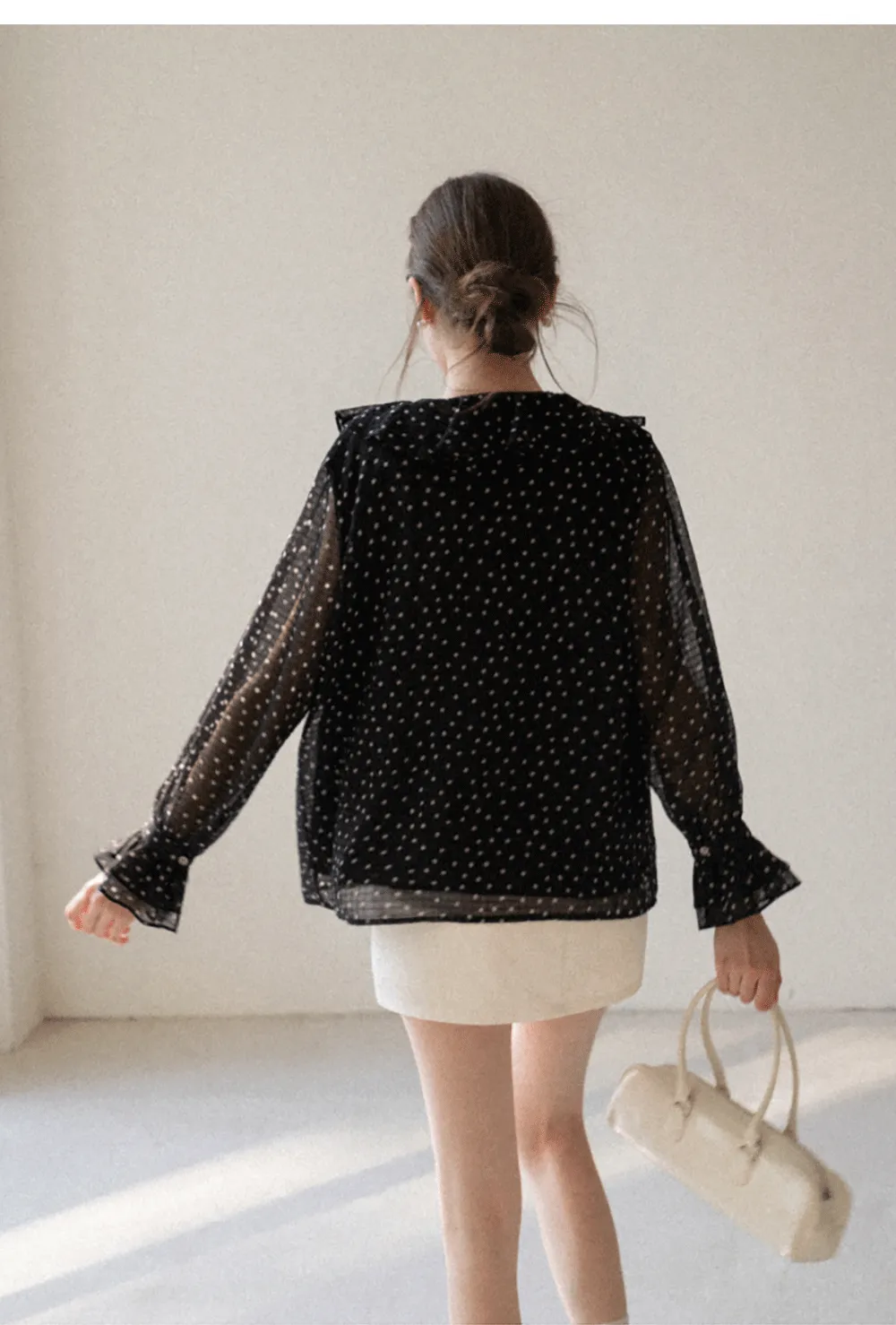 Sheer polka dot blouse with ruffled neckline and long sleeves