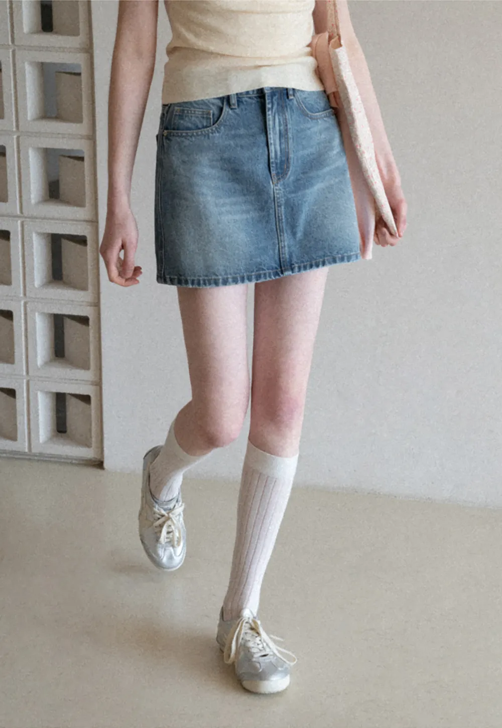 Denim mini skirt with frayed hem and front pockets