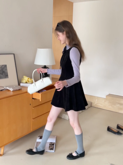 Elegant sleeveless dress with ruffled collar and bow tie design