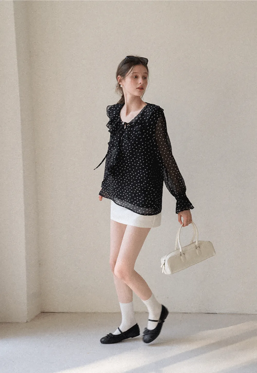 Sheer polka dot blouse with ruffled neckline and long sleeves