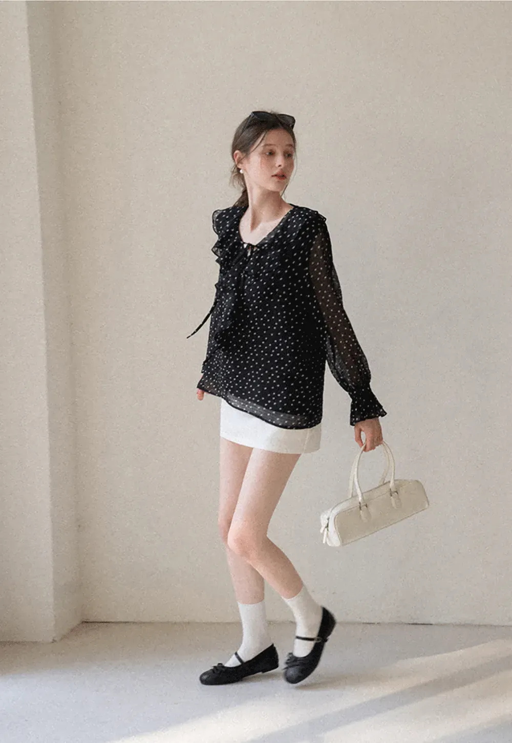 Sheer polka dot blouse with ruffled neckline and long sleeves