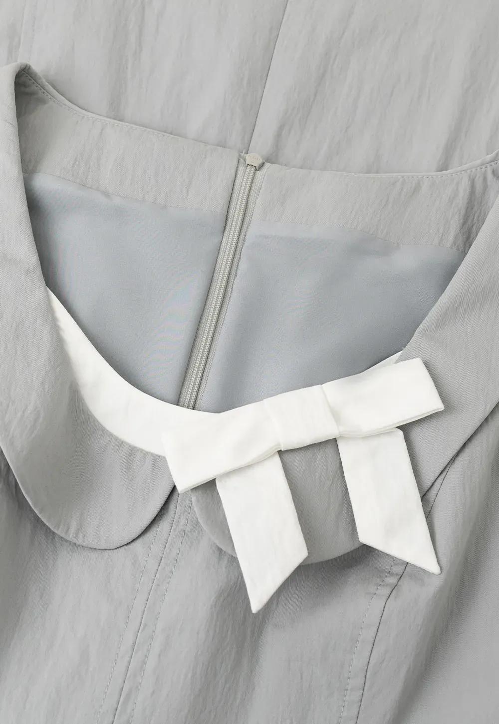 Sleeveless dress with Peter Pan collar and bow detail