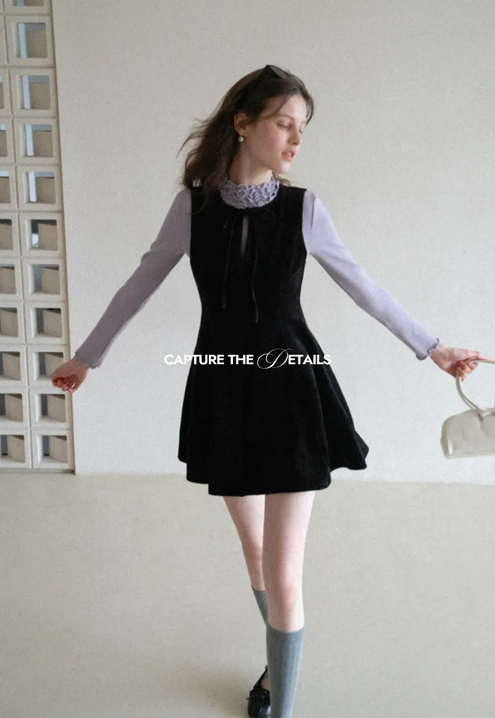 Elegant sleeveless dress with ruffled collar and bow tie design