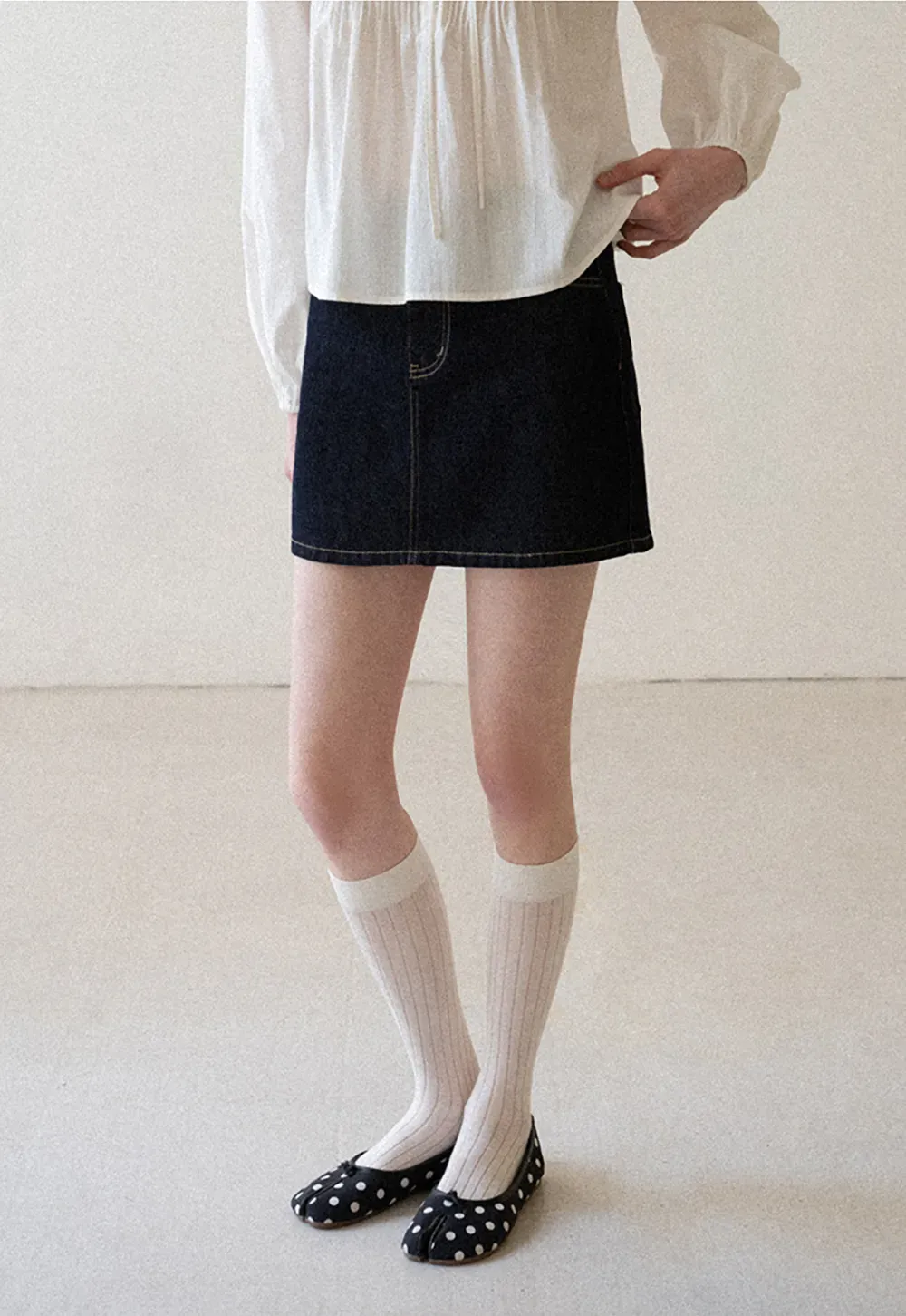 A-line denim skirt with front pocket design and adjustable waistband.