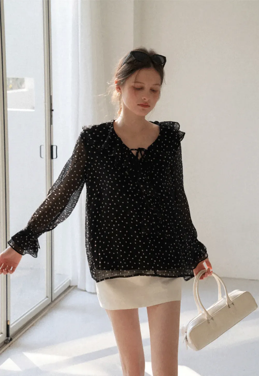 Sheer polka dot blouse with ruffled neckline and long sleeves