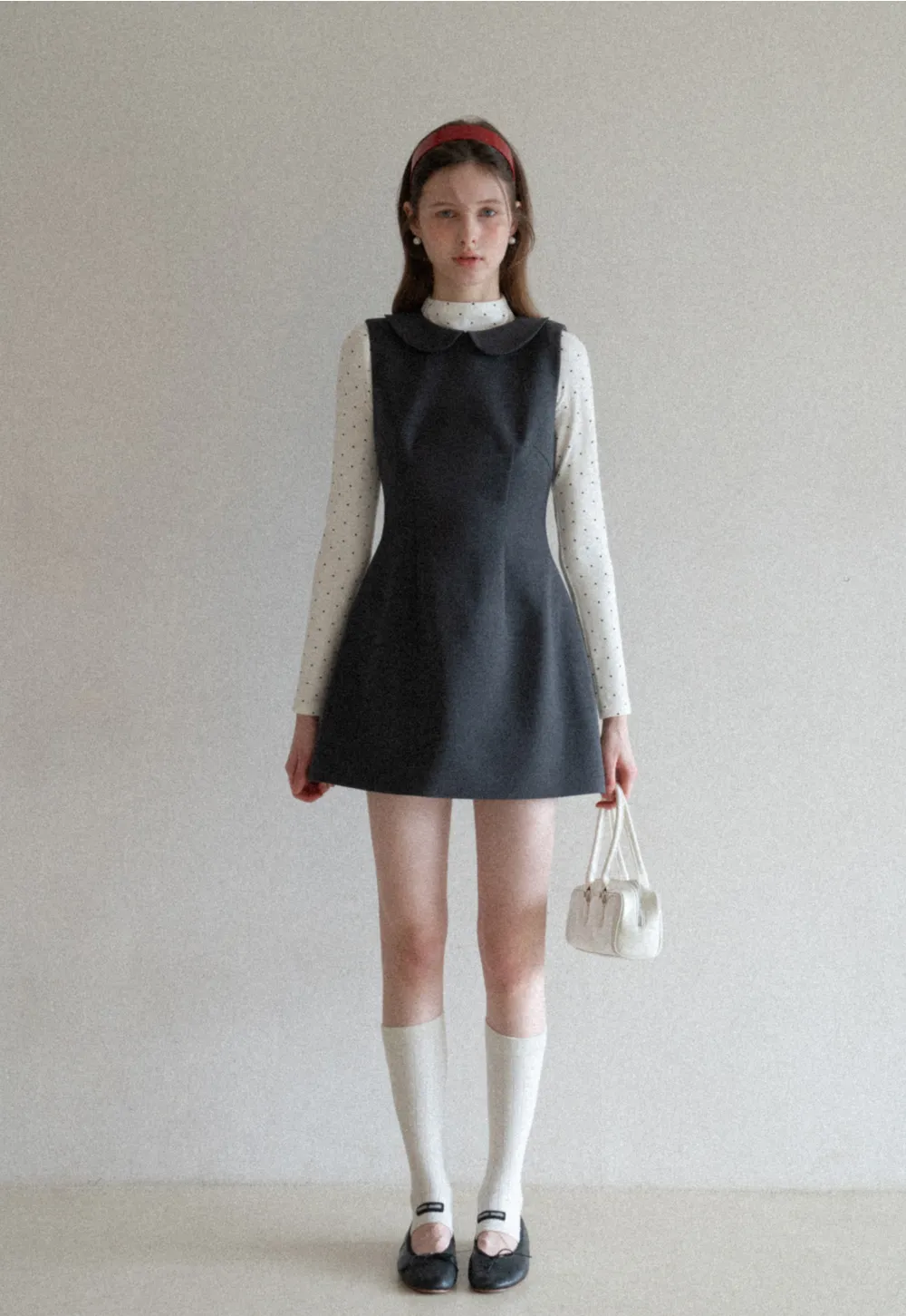 Elegant sleeveless dress with collar layered over polka dot top