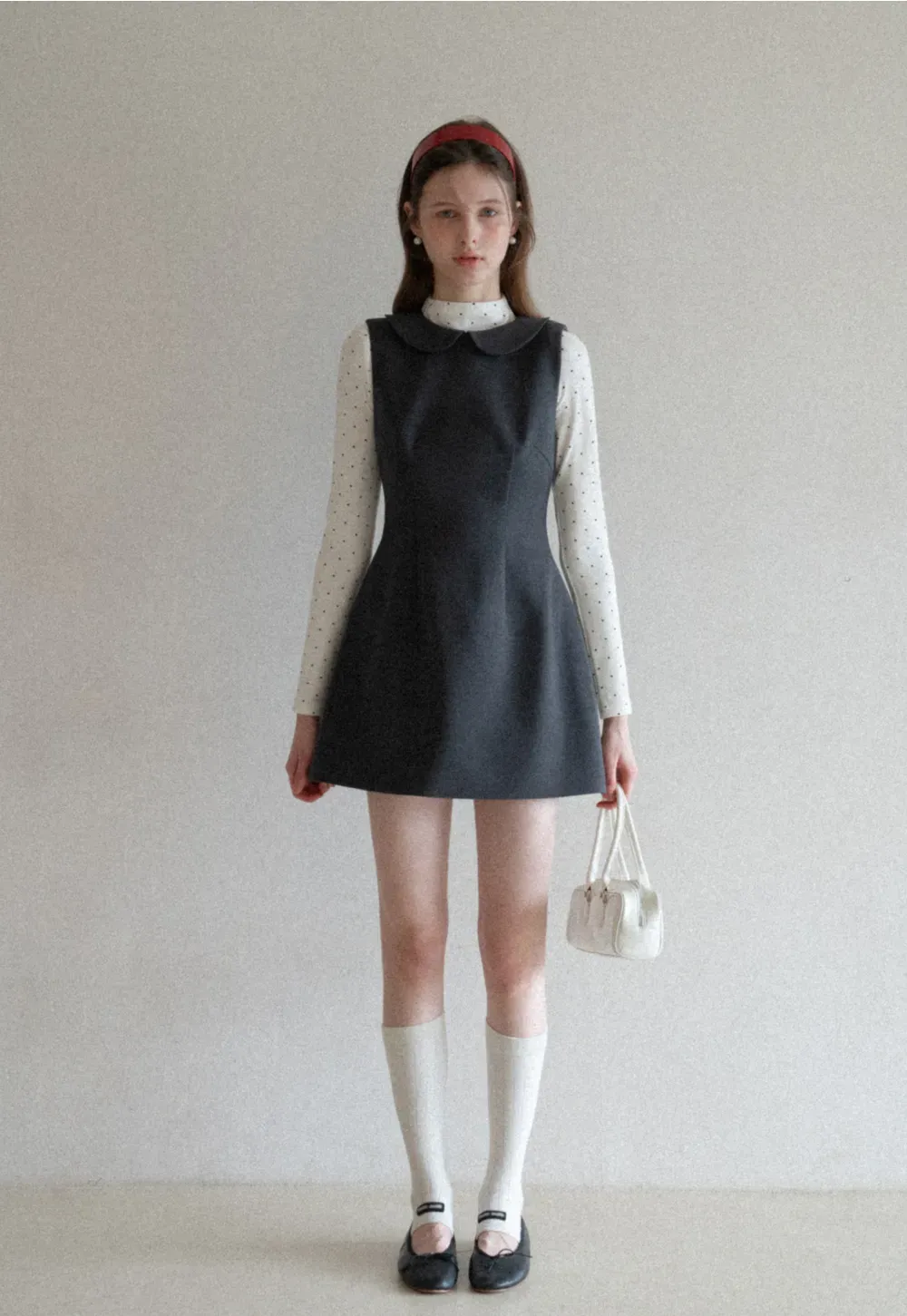 Elegant sleeveless dress with collar layered over polka dot top