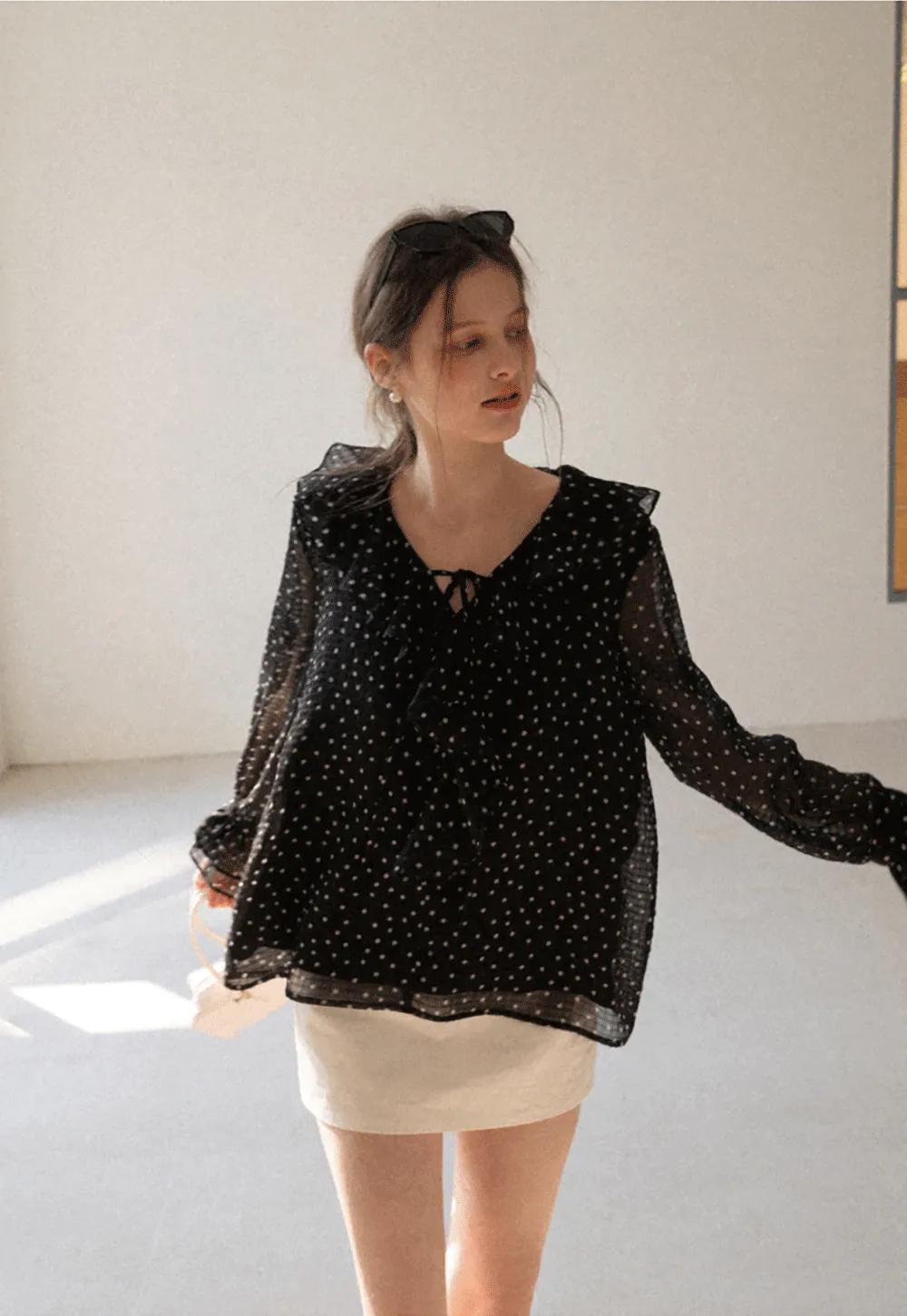Sheer polka dot blouse with ruffled neckline and long sleeves