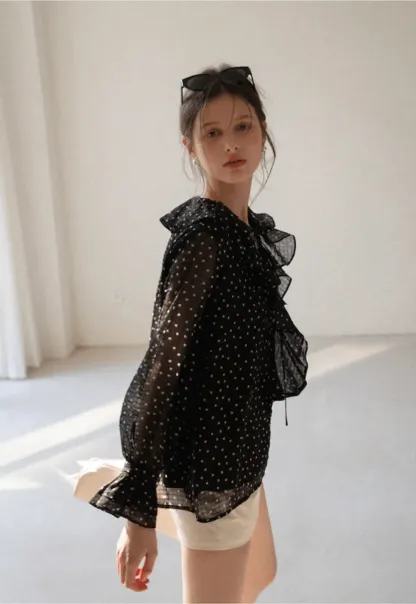 Sheer polka dot blouse with ruffled neckline and long sleeves