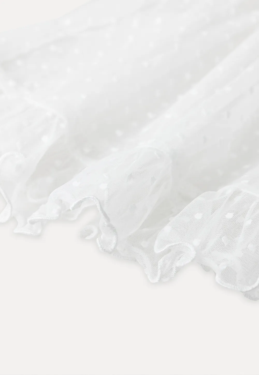 Sheer polka dot top with ruffled hem and puff sleeves