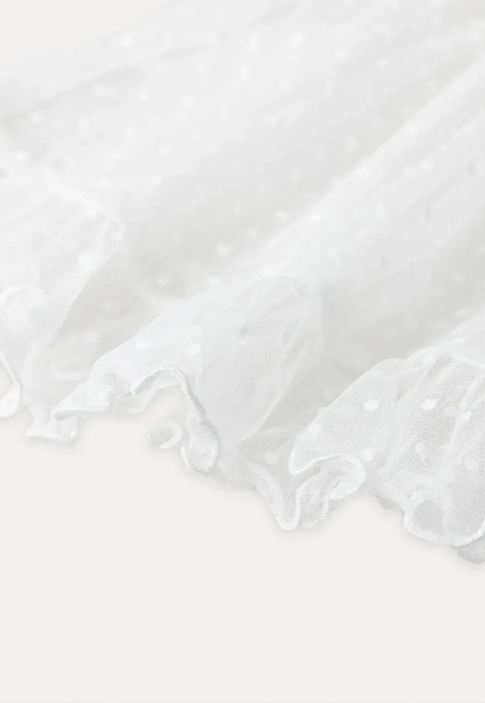 Sheer polka dot top with ruffled hem and puff sleeves