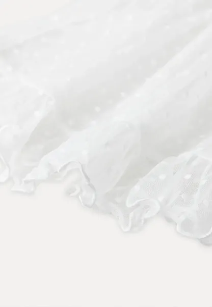 Sheer polka dot top with ruffled hem and puff sleeves