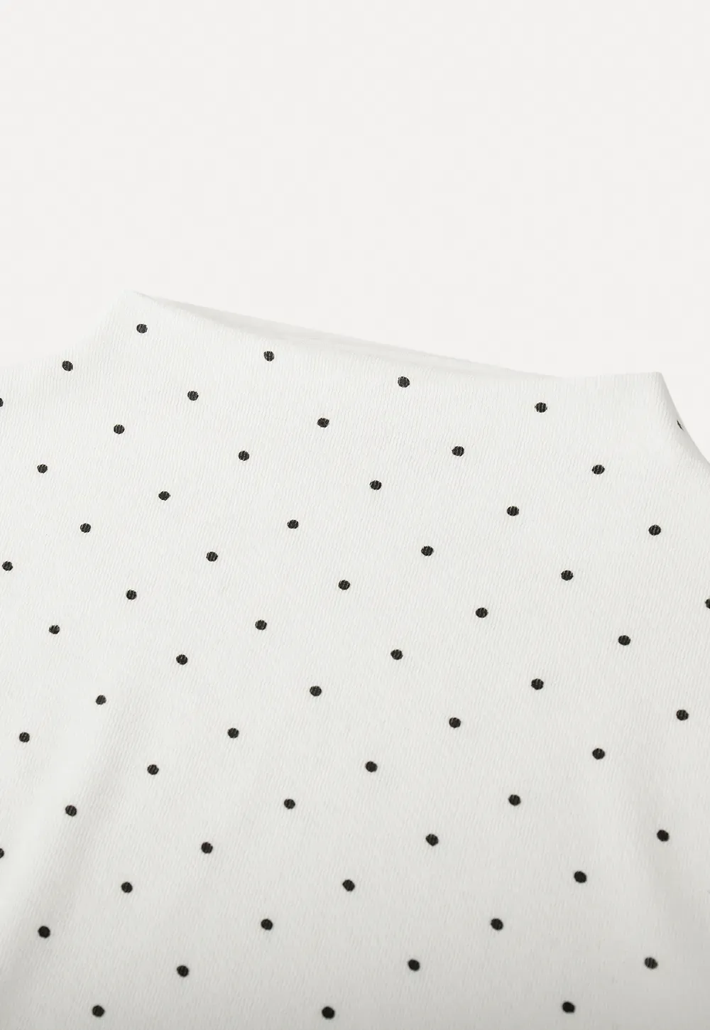 Elegant sleeveless dress with collar layered over polka dot top