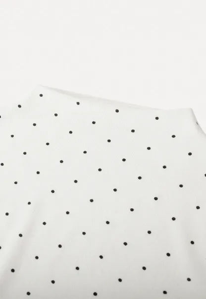 Elegant sleeveless dress with collar layered over polka dot top