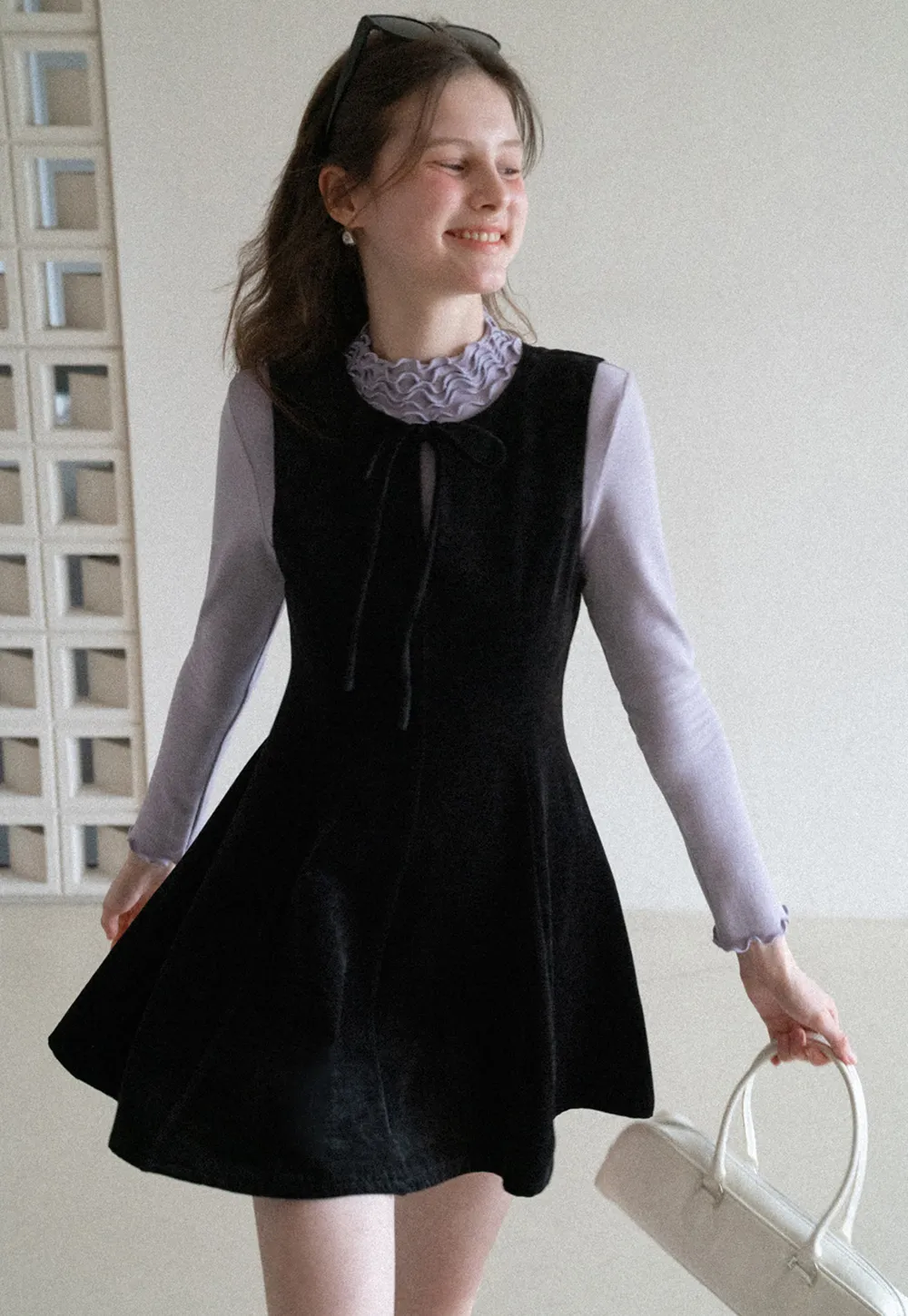 Elegant sleeveless dress with ruffled collar and bow tie design