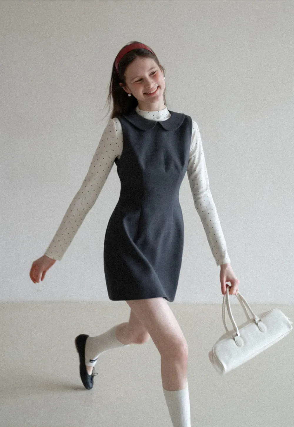 Elegant sleeveless dress with collar layered over polka dot top