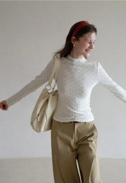 Elegant sleeveless dress with collar layered over polka dot top