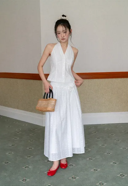 Halter neck sleeveless top with buttons and pleated skirt