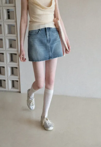 Denim mini skirt with frayed hem and front pockets